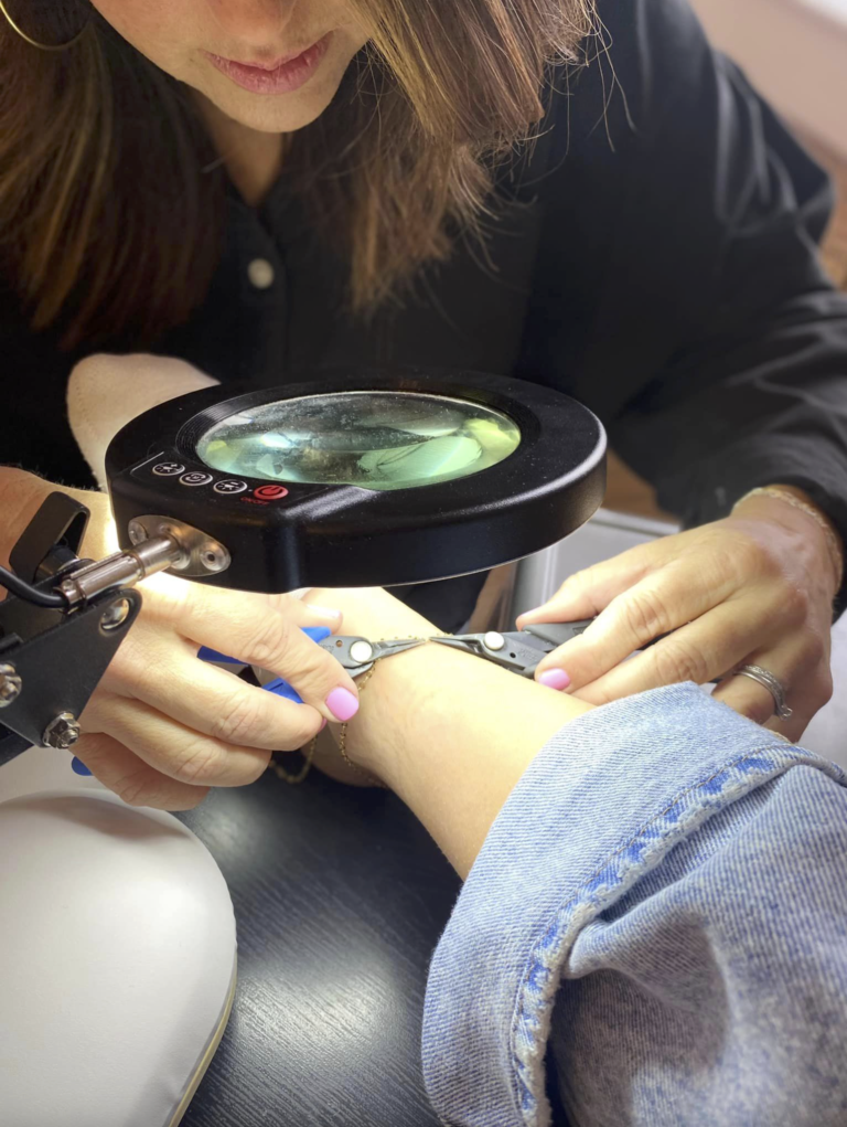 Artist welding at a private permanent jewelry party